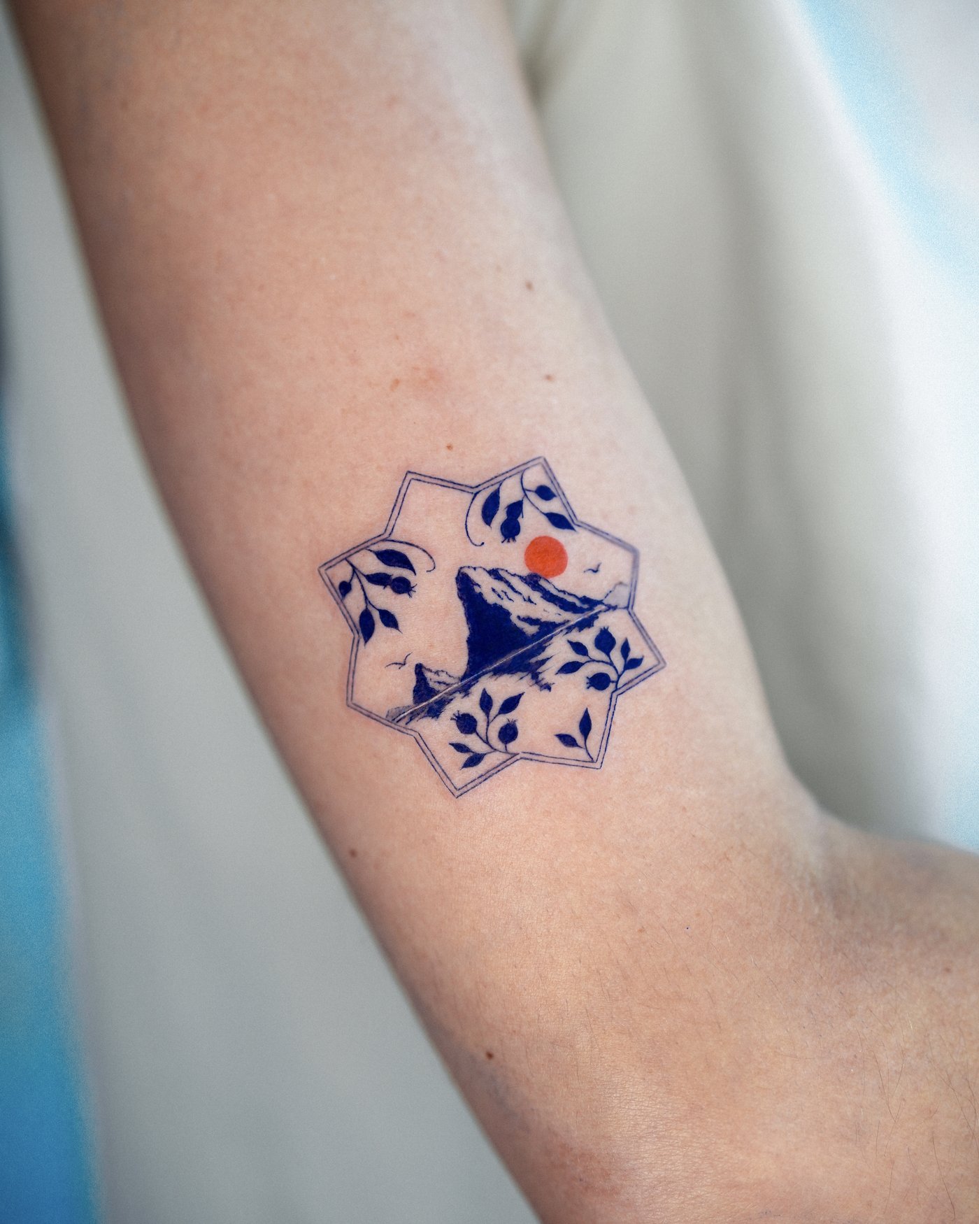 Fine line mountain landscape tattoo with color detail